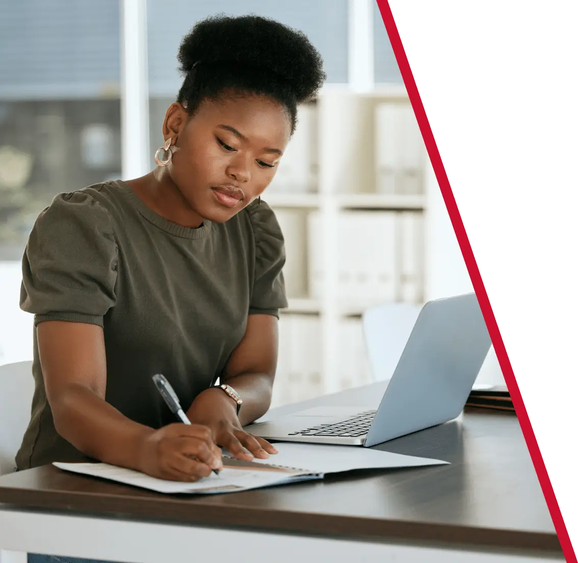 woman sitting and using a laptop and writing